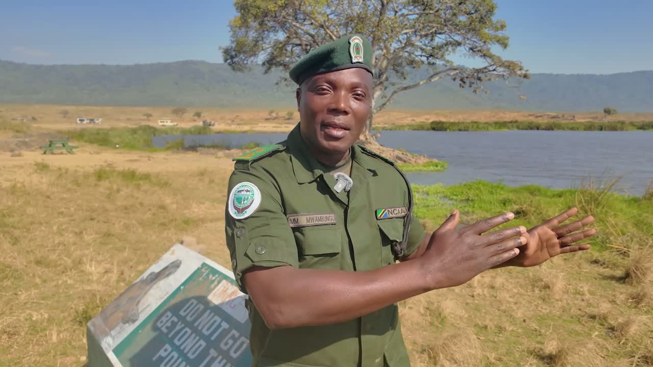 Mecksadeck M. Mwambungu, Ngorongoro conservation ranger, speaking beside the crater-floor hippo pool
